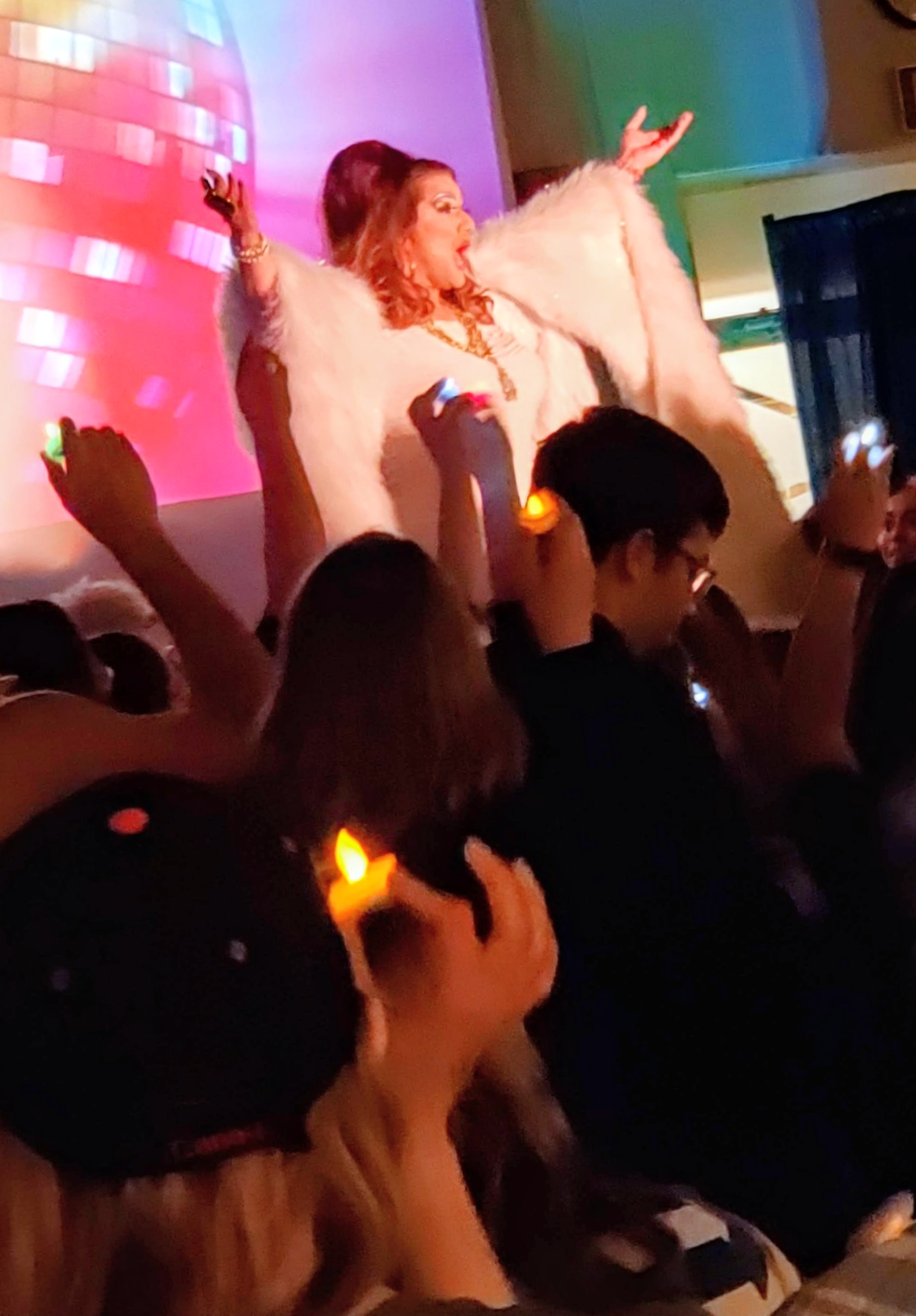 Candi, Wantsome? performing on stage in a white fur coat